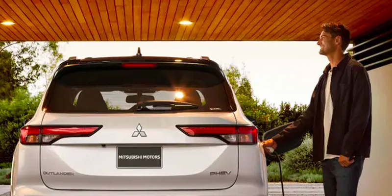 a man plugging in the 2025 Mitsubishi Outlander PHEV.